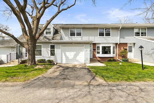 townhome / multi-family property featuring a front yard, a garage, brick siding, aphalt driveway, and entry steps