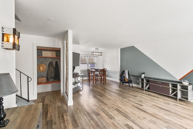 interior space with baseboards, wood finished floors, a chandelier, and stairway