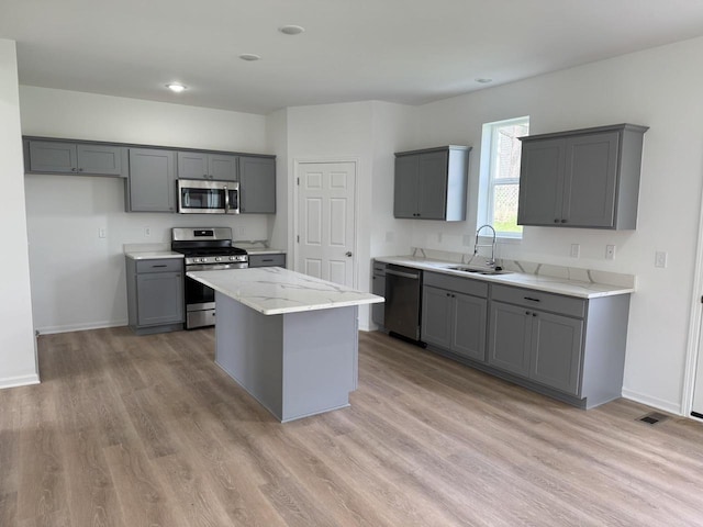 306 Filardo Ct, Mineral Point, WI 53565 - kitchen with gray cabinets, stainless steel appliances, light wood-style floors, a sink, and baseboards