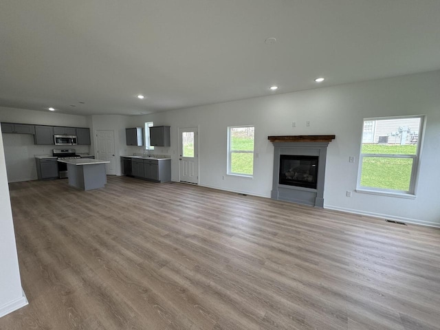 306 Filardo Ct, Mineral Point, WI 53565 - unfurnished living room with a sink, recessed lighting, visible vents, and light wood-style floors