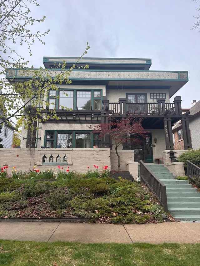 view of front of home with stucco siding and stairs