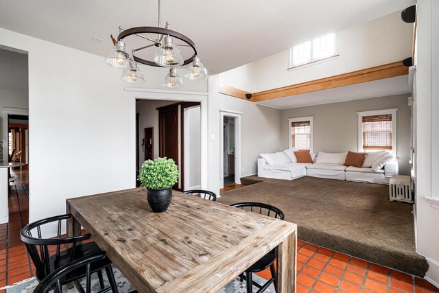 dining area featuring radiator heating unit, carpet, and tile patterned flooring
