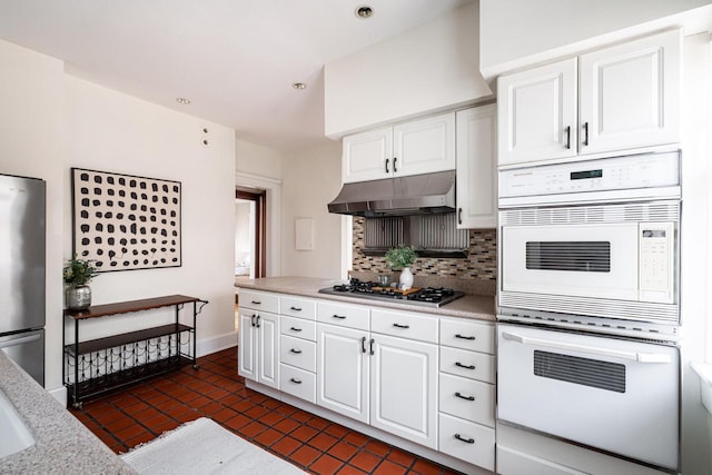 kitchen featuring recessed lighting, under cabinet range hood, appliances with stainless steel finishes, backsplash, and white cabinetry