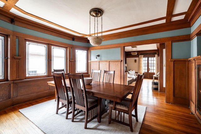 dining space featuring wood-type flooring and ornamental molding