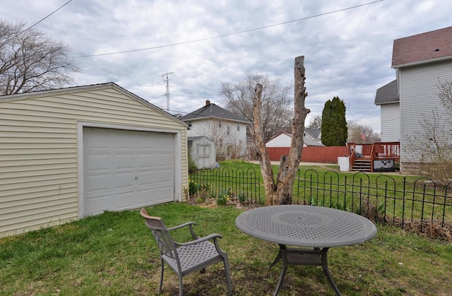 1922 45th St, Kenosha, WI 53140 - view of yard with fence, a garage, a wooden deck, and an outbuilding