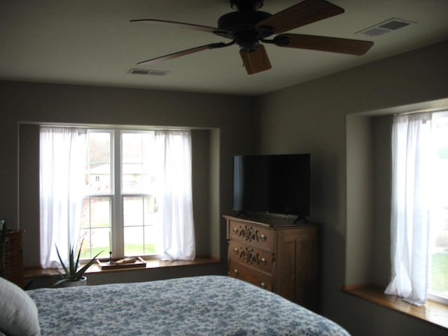 bedroom with visible vents and multiple windows