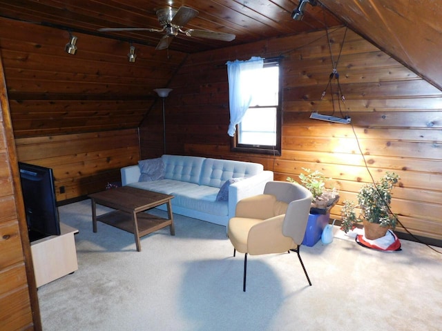 sitting room with wood ceiling, ceiling fan, carpet floors, wooden walls, and vaulted ceiling
