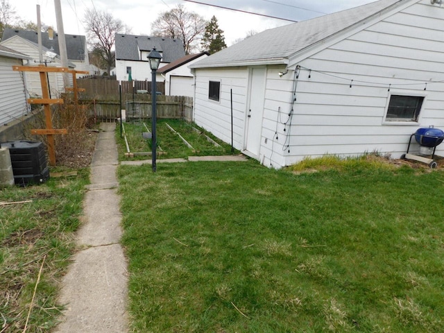 view of yard with fence and central air condition unit