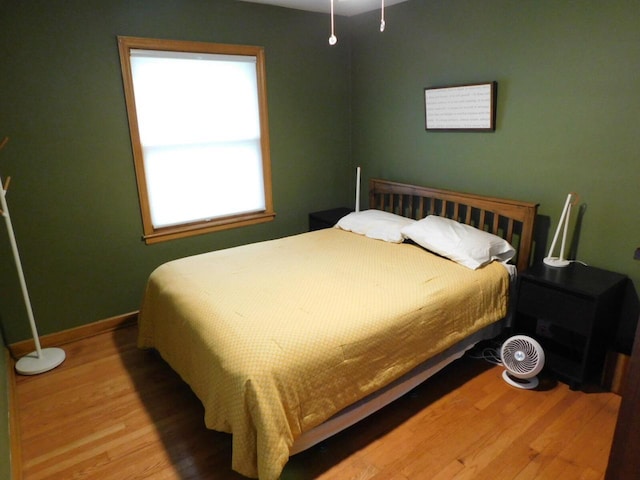 bedroom with baseboards and wood finished floors