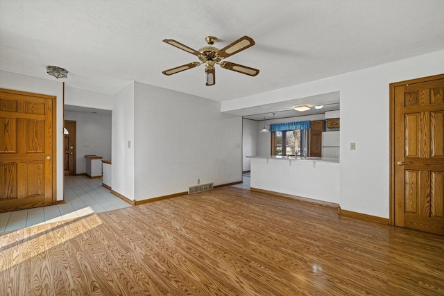 2500 S Brookside Pkwy, New Berlin, WI 53151 - unfurnished living room with a sink, visible vents, a ceiling fan, and light wood-style floors