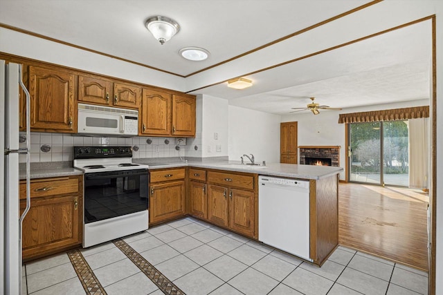 2500 S Brookside Pkwy, New Berlin, WI 53151 - kitchen featuring brown cabinetry, white appliances, a peninsula, and a sink