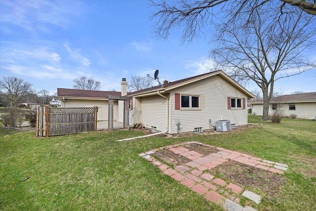 2500 S Brookside Pkwy, New Berlin, WI 53151 - back of house featuring cooling unit, a lawn, fence, and a chimney