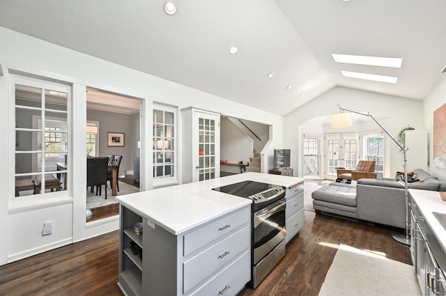 kitchen with gray cabinets, open shelves, light countertops, lofted ceiling with skylight, and stainless steel electric stove