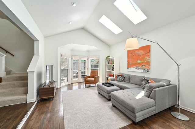 living room with stairway, vaulted ceiling with skylight, french doors, and dark wood finished floors
