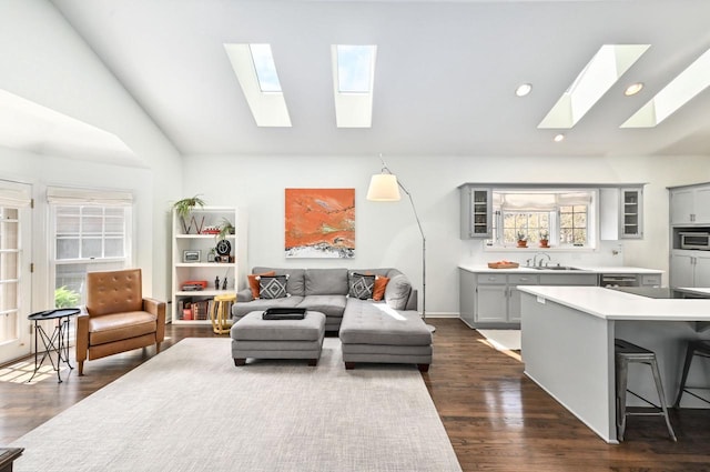 living area with recessed lighting, dark wood finished floors, and vaulted ceiling with skylight