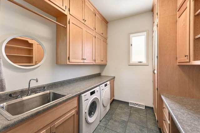 laundry area with visible vents, cabinet space, a sink, baseboards, and washer and clothes dryer