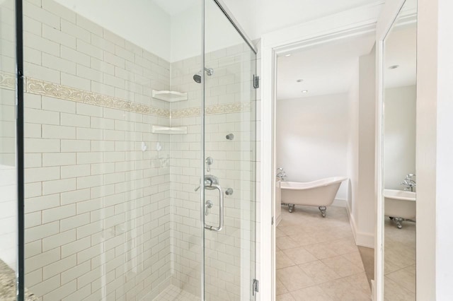 full bathroom with a freestanding tub, tile patterned flooring, and a stall shower