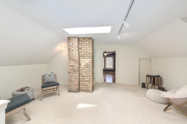 living area featuring track lighting, carpet flooring, and lofted ceiling with skylight