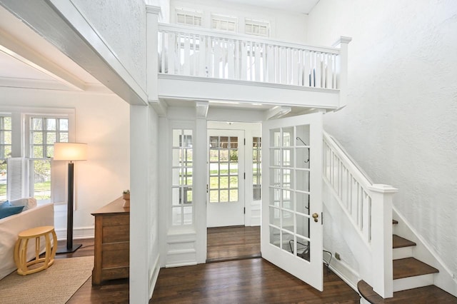 foyer entrance with french doors, a high ceiling, wood finished floors, and stairway