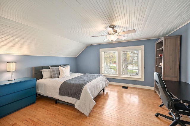bedroom featuring a ceiling fan, visible vents, baseboards, light wood finished floors, and lofted ceiling