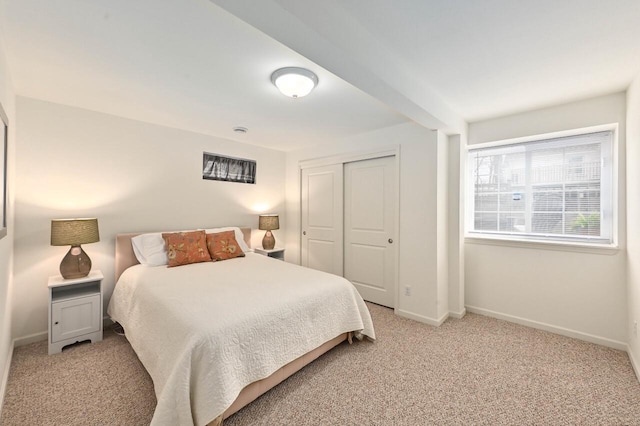 bedroom featuring baseboards, a closet, and light colored carpet