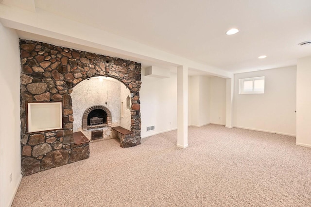 unfurnished living room featuring carpet floors, a stone fireplace, recessed lighting, baseboards, and visible vents