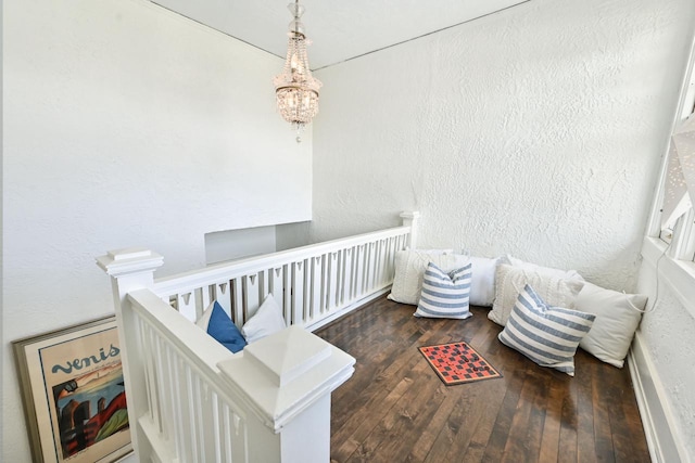 interior space featuring a textured wall, an inviting chandelier, and hardwood / wood-style floors