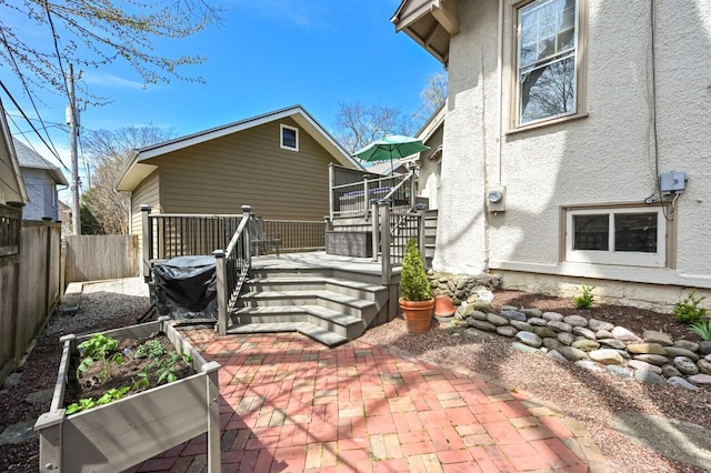 back of property featuring a patio, a fenced backyard, stucco siding, and a wooden deck
