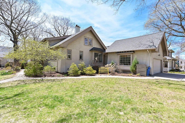 view of front of property featuring a garage, a front yard, stucco siding, a chimney, and driveway