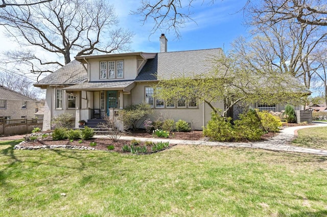 view of front of house featuring fence, stucco siding, a chimney, and a front yard