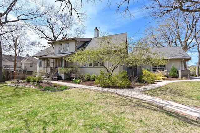 view of front of home featuring fence, stucco siding, a chimney, and a front yard