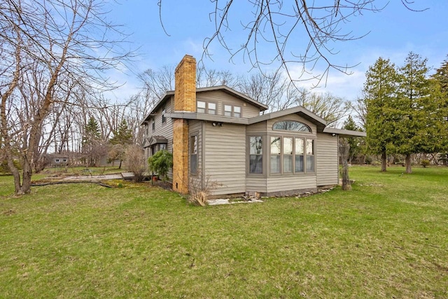2108 Woodlawn Ln, Appleton, WI 54914 - back of house with a chimney and a lawn