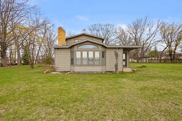 2108 Woodlawn Ln, Appleton, WI 54914 - rear view of house featuring a chimney and a lawn