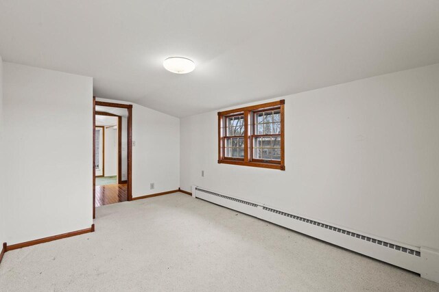 2108 Woodlawn Ln, Appleton, WI 54914 - spare room featuring baseboards, light carpet, lofted ceiling, and a baseboard radiator