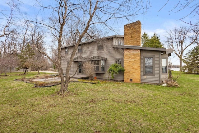 2108 Woodlawn Ln, Appleton, WI 54914 - back of house with a chimney, a yard, and crawl space