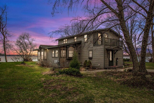2108 Woodlawn Ln, Appleton, WI 54914 - property exterior at dusk with a yard, a balcony, and a water view