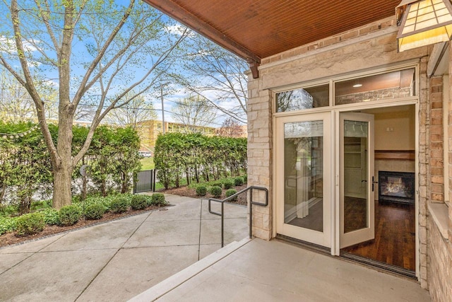 exterior space with a patio, fence, and stone siding