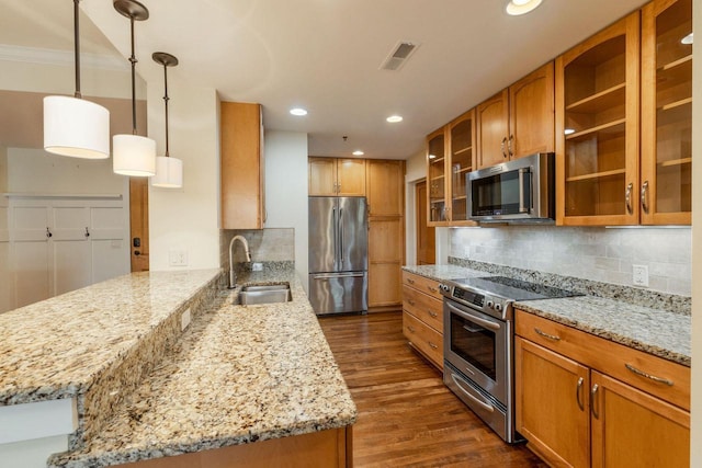 kitchen featuring visible vents, dark wood-style flooring, a peninsula, brown cabinets, and appliances with stainless steel finishes