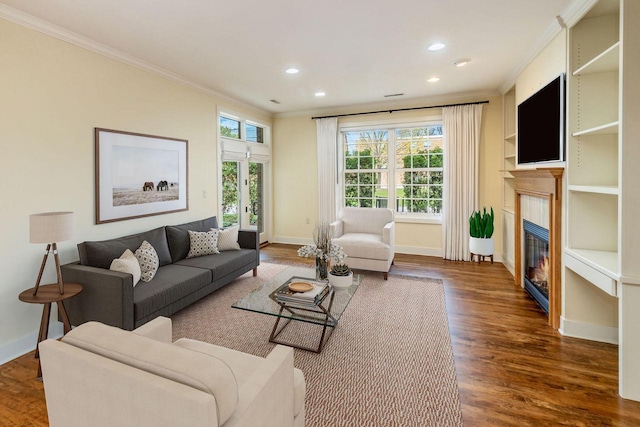 living room featuring baseboards, ornamental molding, wood finished floors, and a fireplace