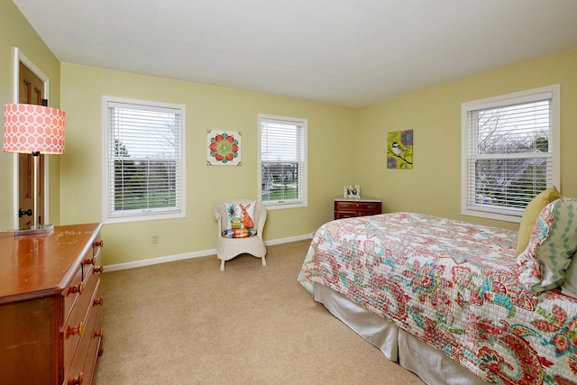 bedroom with light colored carpet and baseboards