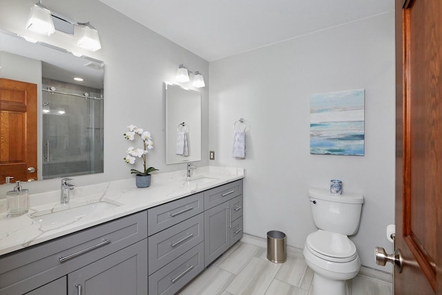 bathroom with a shower stall, toilet, double vanity, and a sink