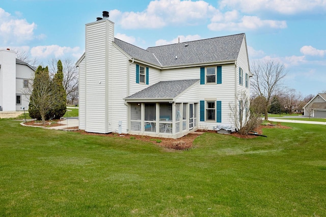 rear view of property featuring a chimney, a yard, a shingled roof, and a sunroom