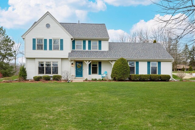 traditional home with a front lawn and roof with shingles