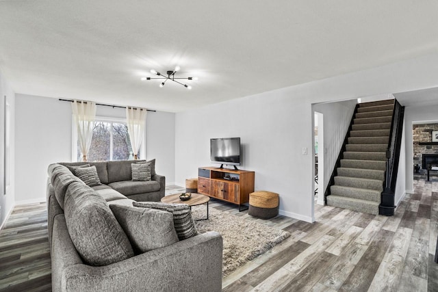 909 Old Tower Rd, Oconomowoc, WI 53066 - living room with baseboards, stairway, wood finished floors, and a stone fireplace