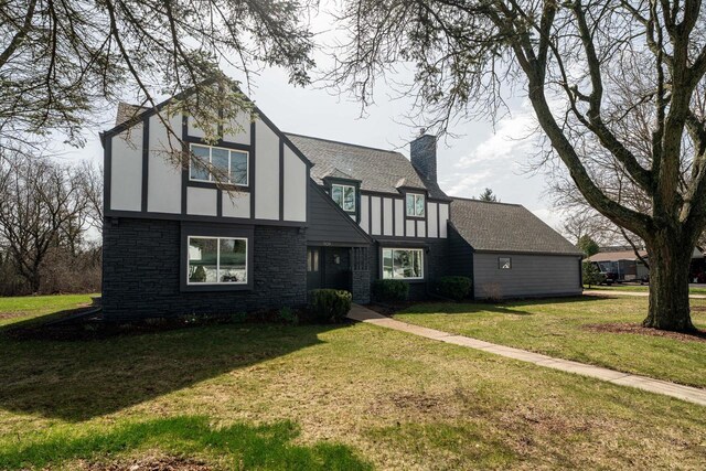 909 Old Tower Rd, Oconomowoc, WI 53066 - tudor house with a chimney and a front lawn