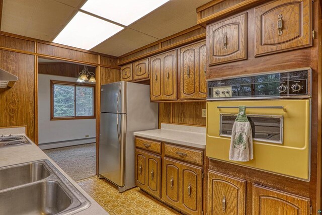 10749 N Namekagon Ln, Hayward, WI 54843 - kitchen with brown cabinets, wall oven, light countertops, baseboard heating, and freestanding refrigerator