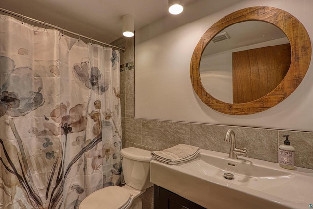10749 N Namekagon Ln, Hayward, WI 54843 - bathroom featuring a shower with shower curtain, toilet, tile walls, vanity, and wainscoting