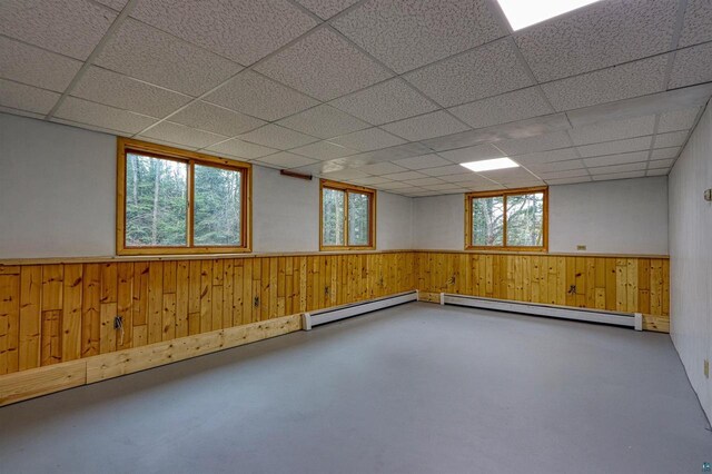 10749 N Namekagon Ln, Hayward, WI 54843 - basement with a baseboard radiator, wooden walls, a wainscoted wall, and a drop ceiling