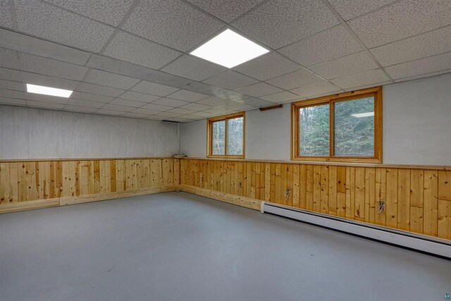 10749 N Namekagon Ln, Hayward, WI 54843 - basement with wooden walls, a paneled ceiling, a baseboard heating unit, and wainscoting