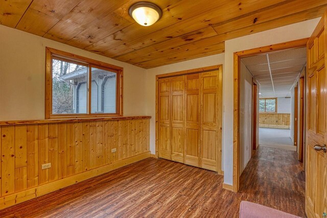 10749 N Namekagon Ln, Hayward, WI 54843 - unfurnished bedroom with wooden walls, multiple windows, wainscoting, and wood finished floors